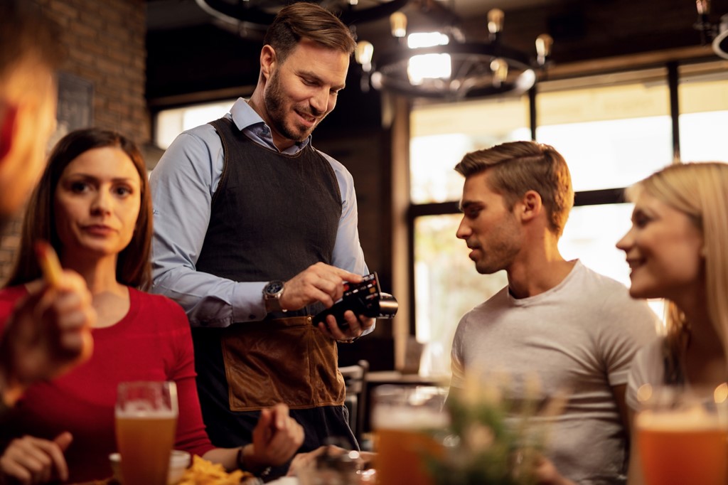 happy-waiter-accepting-payment-by-credit-card-in-a-2023-11-27-05-01-10-utc